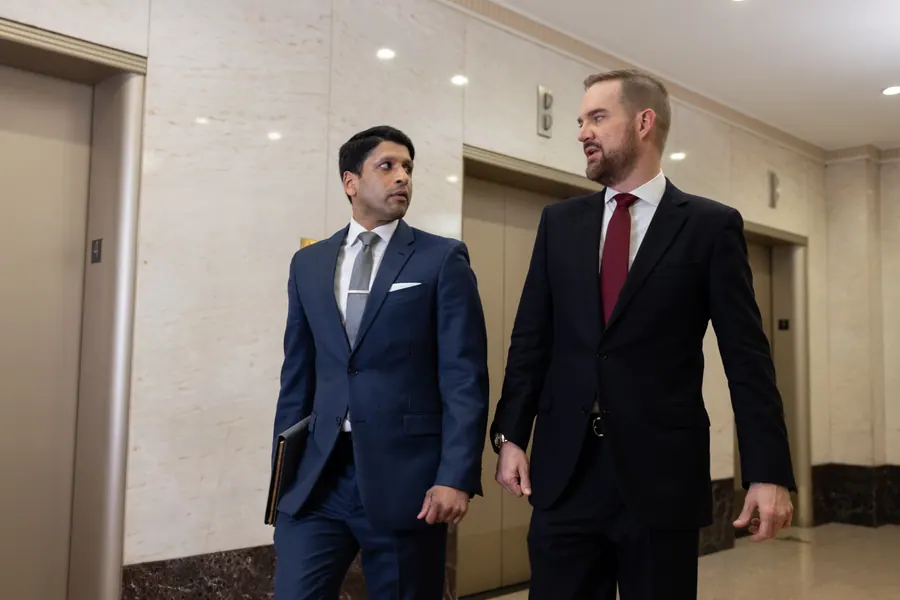 Two attorneys talking as they walk through a Houston office lobby